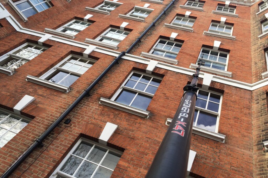 Window cleaning at a Residential block of flats in Leighton Buzzard using a water-fed pole, with the town's architecture visible