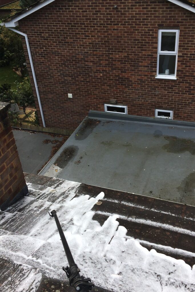 A patio area in Leighton Buzzard being rejuvenated with soft washing, removing grime and brightening the wood and stone surfaces